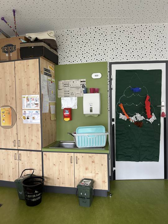 Coin évier d'une crèche, avec un capteur de qualité de l'air fixé au mur